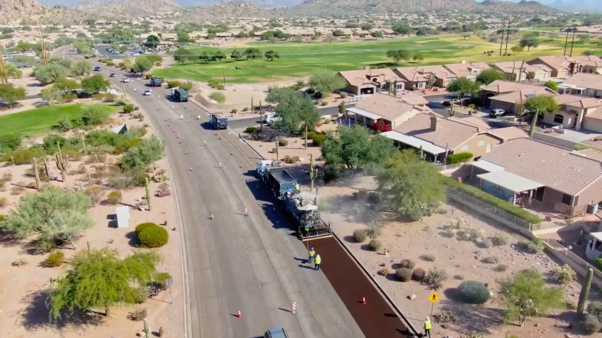 An asphalt-laying machine is paving a road along an Arizona neighborhood roadway.